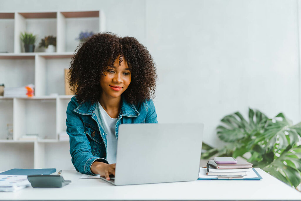 Woman working on laptop as a background screening specialist