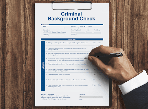 Close up view of a someone signing a criminal background check document