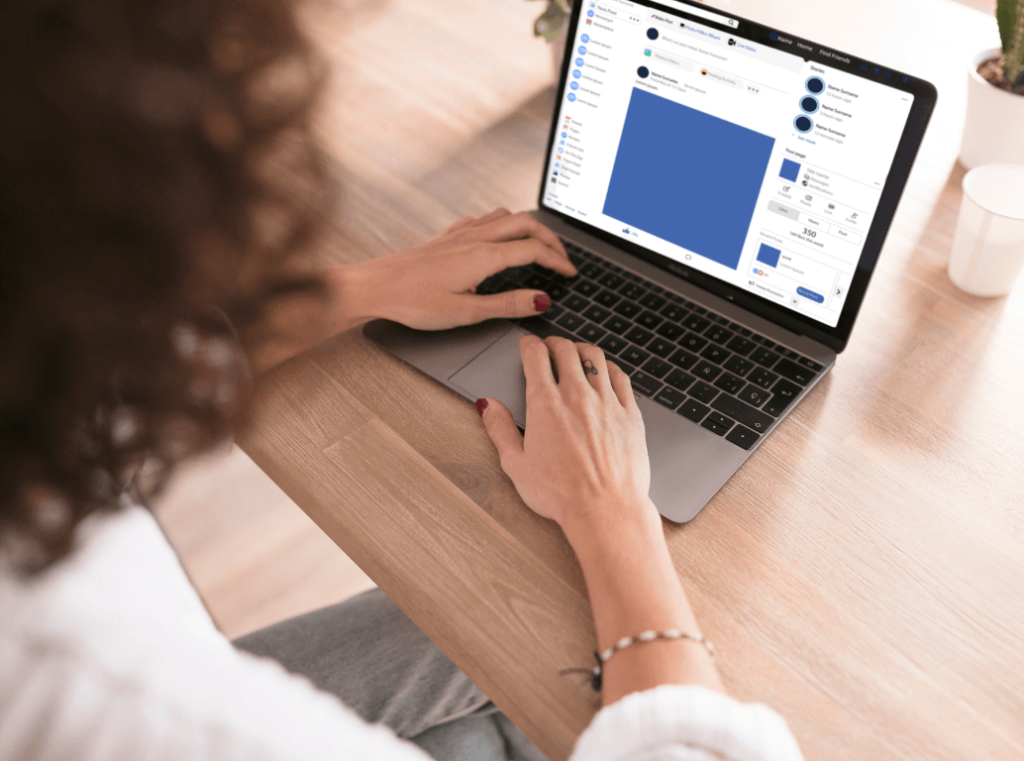 A woman using a laptop to access a social media platform.