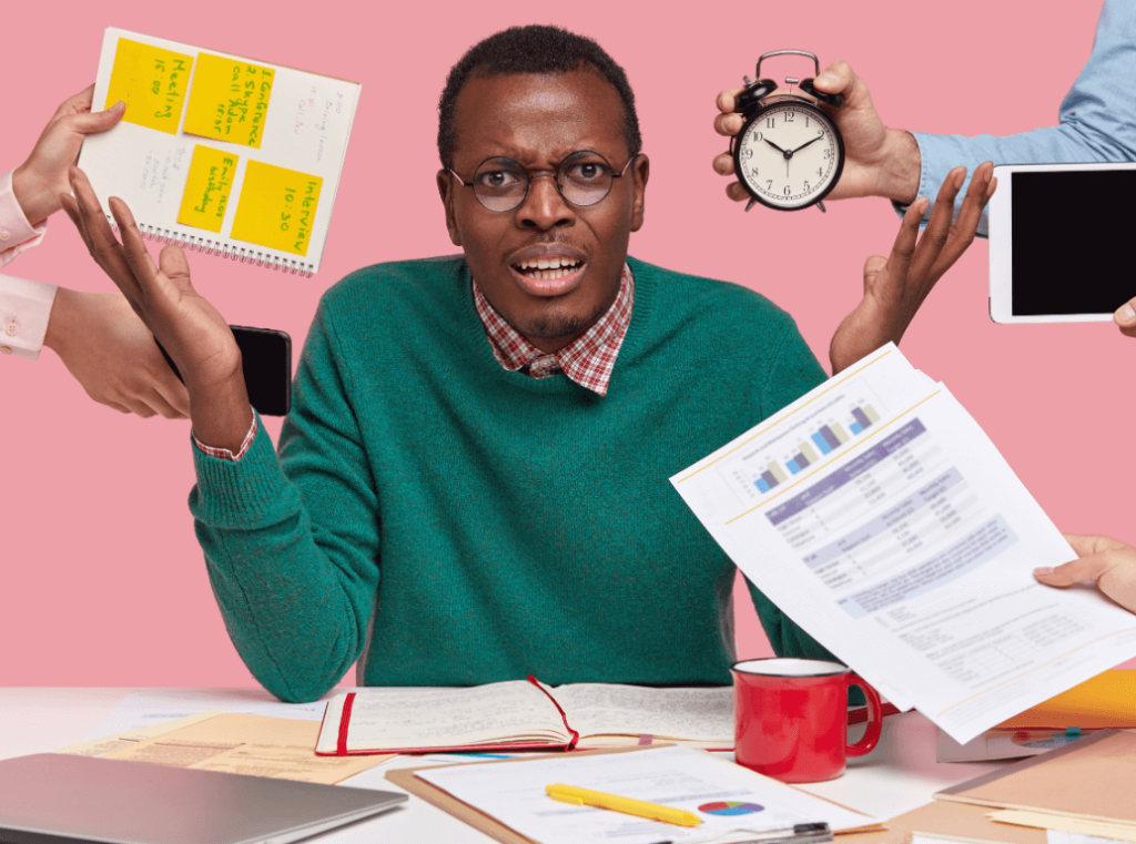 A man looking overwhelmed at a cluttered desk being bombarded with documents and schedules from all directions, capturing the stress of lying on a CV.
