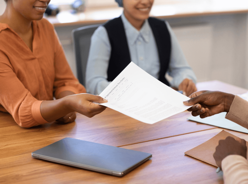 Candidate handing over a signed consent form during a job interview.