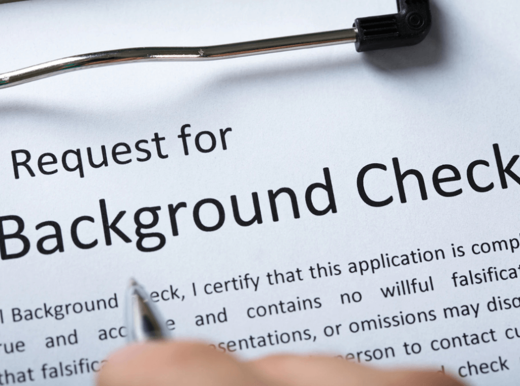 Close-up of a background check request form with a pen and clipboard.