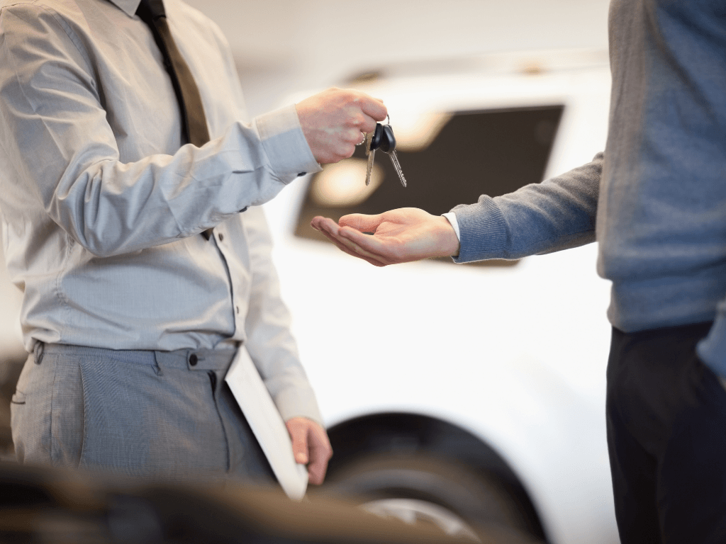 Fleet manager handing over car keys to a company driver, assigning a corporate vehicle.